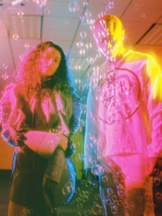 two people standing next to each other in front of bubbles