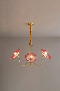 a chandelier with pink flowers hanging from it's sides and two lights on each side