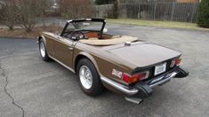 a brown sports car parked in a parking lot