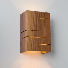 a wooden wall light mounted to the side of a white wall