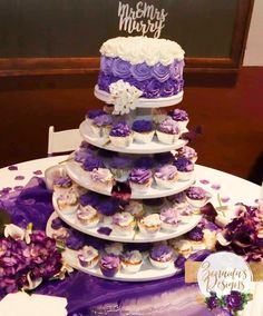 a purple and white wedding cake with cupcakes