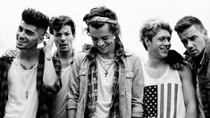 four young men standing next to each other with an american flag on their shirt and jeans