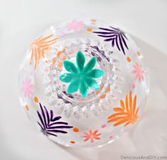 a glass bowl with colorful flowers painted on it