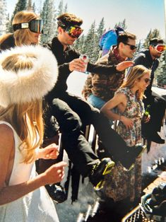 a group of people standing next to each other on top of a snow covered slope