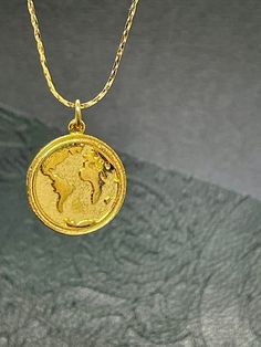 Introducing our stunning brass necklace featuring a beautiful round earth map pendant. This unique and eye-catching piece is perfect for any globe-trotter or lover of travel. The intricate map detailing adds a touch of elegance and sophistication to any outfit, making it the perfect accessory for any occasion. Stand out and showcase your love for exploring the world with this exquisite necklace. Celestial Gold Necklace With Coin Pendant, Gold Spiritual Compass Necklace, Gold-tone Brass Coin Necklace, World Necklace, World Map Necklace, Earth Map, Map Pendant, Map Necklace, Brass Necklace