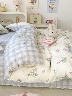 a child's bed with blue and white plaid sheets, pillowcases and stuffed animals