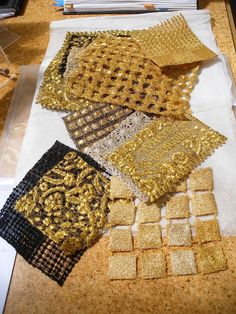 gold and black sequins are laid out on a table