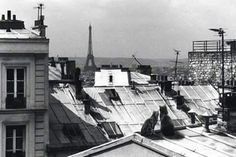 black and white photograph of rooftops with buildings in the background