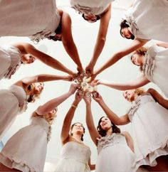 a group of women standing in a circle with their hands together