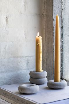 two candles sitting on top of some rocks