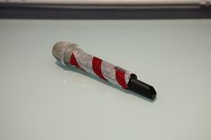 a red and white striped pen sitting on top of a table