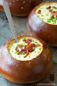 two bread bowls filled with soup and topped with bacon