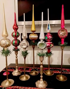 there are many different colored glass ornaments on the table and in front of the tv