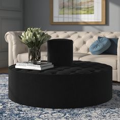 a living room with a white couch and black ottoman