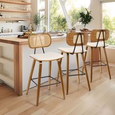 three wooden stools sit in front of an island with shelves on the wall and windows