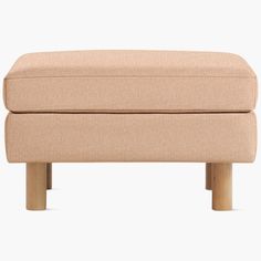 a beige foot stool with wooden legs