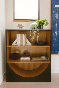 a book shelf with books and plants on it