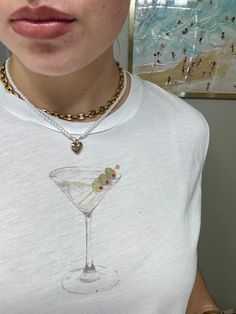 -Add an eclectic look to your wardrobe with our hand-painted dirty martini glass & hand-beaded olives on a loose-fitted baby tee!  -Available in sizes S, M, L, XL, & 2XL (fits true to size, with hem hitting right above hips) -Made to order - Ships within 1-10 business days! -3.7 oz., 65% polyester, 35% viscose, 32 singles -Tailored sleeve -Modest crop -Side seamed -Flowy fit -Tear away label Martini Outfit, Olive Aesthetic, Martini Shirt, Lace Coquette, Graphic Baby Tee, Woman Outfit, Paint Shirts, T Shirt Crop Top, Baby Graphic Tees