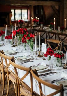 a long table is set with red roses and candles