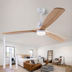 a living room with a couch, ceiling fan and large bed in the middle of it