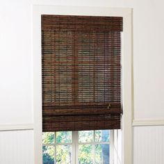 the blinds in this room are made out of bamboo and have been pulled down to allow shade