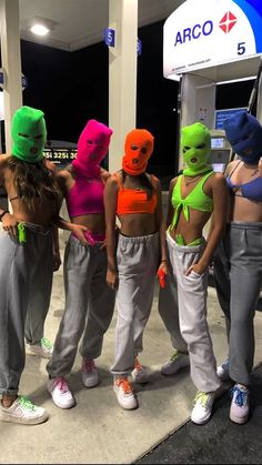 four women in neon masks standing next to each other