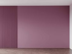 an empty room with purple walls and wooden floors