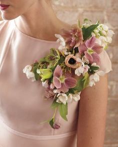 a woman wearing a pink dress with flowers in her hair and holding a flower bouquet