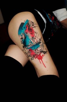 a woman's leg with music notes and paint splattered on it,