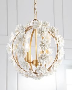 a chandelier with white flowers hanging from the ceiling