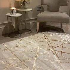 a chair and table in a room with flowers on the side tables next to each other