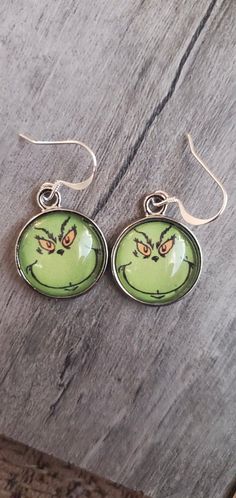 Adorable Round Grinch Face Earrings On Sterling Silver Earwires.Handmade - Shipped From Saint Louis, MO. Grinch Face Earrings, Fun Nickel-free Silver Earrings, Fun Round Ear Wire Jewelry, Fun Hoop Earrings With Ear Wire As A Gift, Fun Drop Earrings With Ear Wire, Adjustable Round Fun Earrings, Fun Green Round Jewelry, Novelty Metal Earrings With Ear Wire, Fun Round Earrings As A Gift