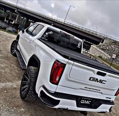 a white truck parked in front of a bridge