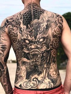 the back of a man with tattoos on his body