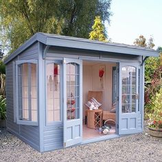 a small blue shed sitting in the middle of a yard