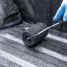 a person in blue gloves is using a sponge to clean the carpet on a car