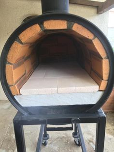 an outdoor brick oven is shown with the door open to show it's interior