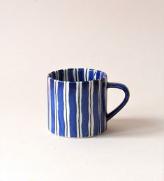 a blue and white striped mug sitting on top of a table