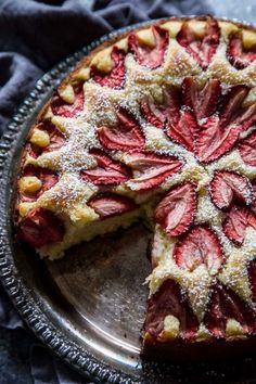 a piece of pie with powdered sugar on top is sitting on a silver plate