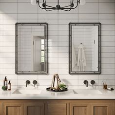 a bathroom with two sinks and mirrors on the wall next to each other in front of a light fixture