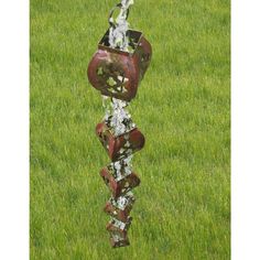 a rusted metal sculpture sitting on top of a lush green field