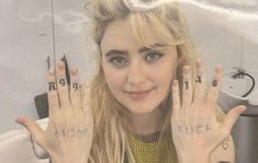 a woman with her hands in front of her face and the word mom written on her fingers