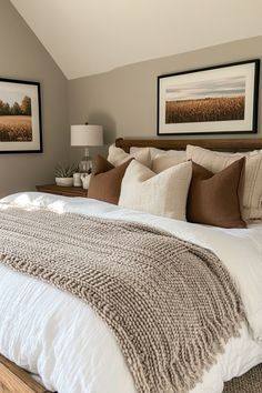 a large bed sitting in a bedroom next to two pictures on the wall above it