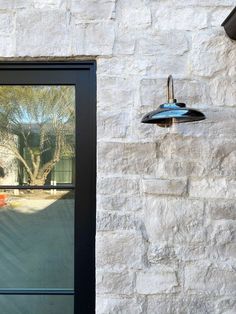 an outside view of a house with a black door and light fixture on the side