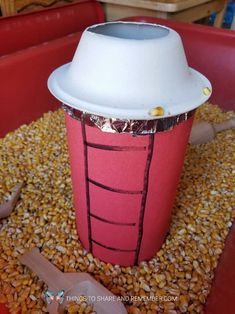 a paper cup sitting on top of a pile of corn