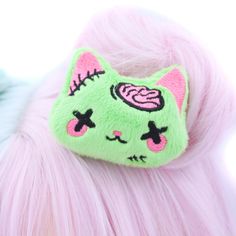 "Add a touch of adorable undead charm to your look with our Plush Anime Style Kawaii Zombie Kitty Hair Clip! Crafted from bright lime green minky fabric, this hair clip features a sweet-faced kitty with hot pink brains and stitches embroidered using the highest quality threads. Each detail is meticulously designed and digitized by me, ensuring a unique and delightful accessory. Handmade with love in the USA, this super cute zombie kitty hair clip is perfect for adding a playful twist to your ens Kawaii Plush Hair Clip, Yume Kawaii Hair Accessories, Zombie Cosplay Female, Pink And Green Accessories, Cute Face Accessories, Cute Cat Ears Costume Accessories, Cute Costume Accessories For Halloween Cosplay, Cute Halloween Costume Accessories, Pink Novelty Costume Accessories For Halloween