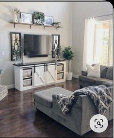 a living room filled with furniture and a flat screen tv on top of a entertainment center