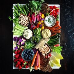 a platter filled with assorted vegetables and dips