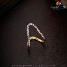 a diamond ring on top of a brown leather surface with the words navrathhan jewelers all rights reserved