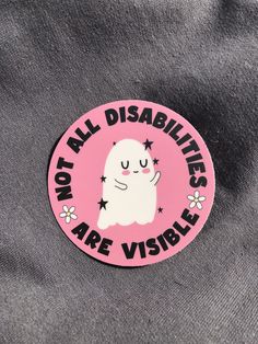 a pink sticker that says not all disabilities are visible on a grey t - shirt